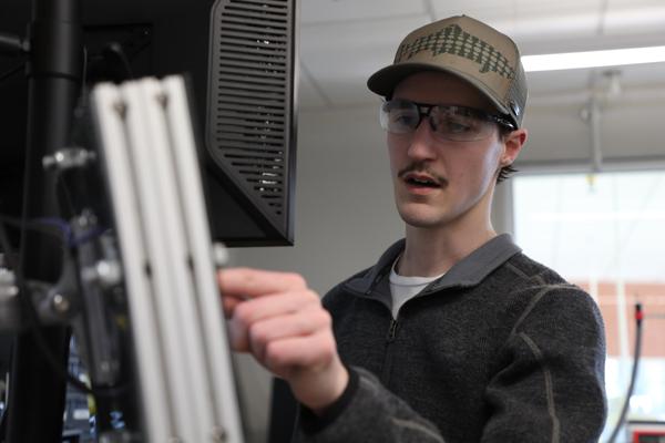 Master's student pointing at a computer monitor